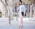 We can review it once I get there. a young businesswoman making a phone call using her smartphone. Royalty Free Stock Photo