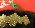 Vintage fortune-telling cards lie on a black fur with vintage decorations on a red table.