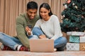 We can shop for everyone online. a young couple using a laptop and credit card during Christmas at home. Royalty Free Stock Photo