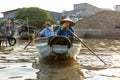 A man and woman paddle through the Cai Rang floating market in C