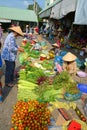 CAN THO, VIETNAM - Mar 19, 2014: Lady buys vegetables from a street stall near the covered market in Can Tho, Vietnam Royalty Free Stock Photo