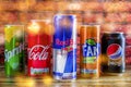 A can, tin of fresh Coca Cola, red bull, sprite, pepsi, fanta drink with brick wall backround. Coca-Cola company is the most popu