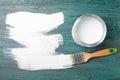 Can of white paint and brush on teal wooden background, flat lay. Space for Royalty Free Stock Photo
