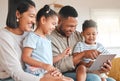 Can you believe how theyve grown. a young family happily bonding while using a digital tablet together on the sofa at Royalty Free Stock Photo