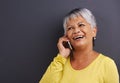 Can you hear me now. a mature woman talking on a mobile phone in a studio. Royalty Free Stock Photo