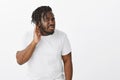 Can you repeat what you said. Portrait of curious good-looking plump african man with beard in white t-shirt, turning Royalty Free Stock Photo