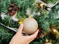 Can you tell what time it is. an unrecognizable person decorating a Christmas tree at home.