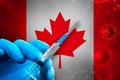 Canada Covid-19 Vaccination Campaign. Hand in a blue rubber glove holds a syringe with covid-19 virus vaccine in front of Canada Royalty Free Stock Photo