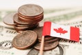 Canada flag with coins on dollar banknotes background