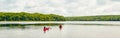 Canada forest park nature with family friends riding in red kayaks canoe boats in water.