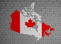 Canada map country silhouette in national Canadian flag colors and with maple leaf on the gray painted brick wall background textu Royalty Free Stock Photo