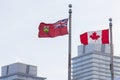 Canada and Ontario flags in front of skyscrapers in Toronto
