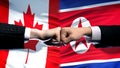 Canada vs North Korea conflict international relations, fists on flag background Royalty Free Stock Photo