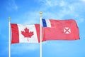 Canada and Wallis and Futuna two flags on flagpoles and blue cloudy sky