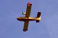 A Canadair seaplane from the Kingdom of Spain crosses the sky to refill water in the port