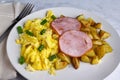 canadian bacon on scramble egg with home fries