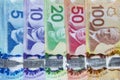 Canadian bills line up on a vertical view. Canadian dollar tumbles to seven-week low as virus contagion escalates.