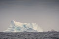 A Canadian Coast Guard ship passes a large coastal iceberg Royalty Free Stock Photo