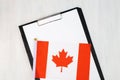 Canadian document, mockup for text on clipboard, white sheet of paper in a folder for notes with Canadian flag Royalty Free Stock Photo