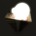 Canadian dollar stack with shiny lightbulb Royalty Free Stock Photo