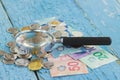 Canadian dollars, coins and magnifying glass on the wooden background Royalty Free Stock Photo