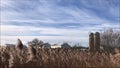 Landscape sweeping view of farm buildings and fields in winter.