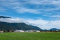 Canadian Farmland With Blue Cloudy Sky. Countryside Farm in the morning. Green agricultural field next to farm Royalty Free Stock Photo