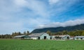 Canadian Farmland With Blue Cloudy Sky. Countryside Farm in the morning. Green agricultural field next to farm Royalty Free Stock Photo