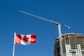 Canadian flag with apartment building under construction in the background, Canadian economy and housing market