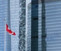 Canadian Flag flying in front glass facade office Royalty Free Stock Photo