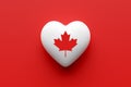 Canadian flag on a heart shape on red background. Canadian national symbol maple leaf. Canadian patriotism, love, respect and Royalty Free Stock Photo