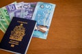 Canadian passport with Canadian money on brown background