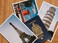 Canadian passport with selection of European travel photos on wooden table