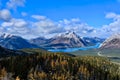 Canadian Rockies landscape with lakes and mountains covered with snow and golden larches in autumn.