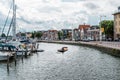 Canal of Alkmaar with nautical vessels and cityscape a cloudy da