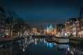 Canal of Amsterdam at night with beautiful old buildings, bridge and water reflection, Netherlands Royalty Free Stock Photo