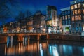 Canal of Amsterdam at night with illuminated bridge. Amsterdam - tourist capital of Netherlands Royalty Free Stock Photo