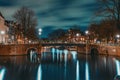 Canal of Amsterdam at night with illuminated bridge. Amsterdam - tourist capital of Netherlands Royalty Free Stock Photo
