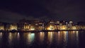 Canal of Amsterdam at night with reflection of illuminated houses in water, Netherlands. Beautiful old European city Royalty Free Stock Photo