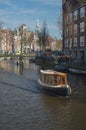 A canal boat making its way down Amsterdam canal