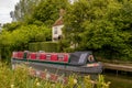 Canal boat outside cottage next to the canal in Wiltshire, UK.