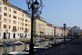 Canal with boats, lampposts and buildings under the blue sky in Trieste in Friuli Venezia Giulia (Italy) Royalty Free Stock Photo