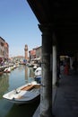 Canal with boats and street in Burano island - Venice, italy