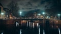 Canal with bridge in night illumination with clouds, Amsterdam, Netherlands Royalty Free Stock Photo