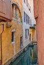 Canal flowing between houses, roads and streets in the medieval part of the city of Annecy in France. Secluded and