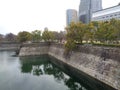 Canal with granite stone walls, greenery, building with cloudy sky, Osaka 2016