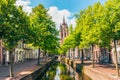 Canal with Leaning Church Tower in Delft Netherlands Royalty Free Stock Photo