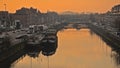 Canal with living boats and apartmet blocks in orange evening light in Ghent Royalty Free Stock Photo