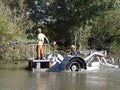 A canal and river trust floating barge used for brush clearing