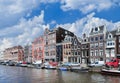 Canal with row of stately ancient mansions with moored boats, Amsterdam, Netherlands